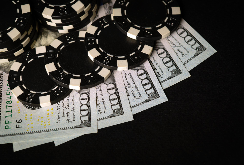 Black playing chips put on top of dollar bills